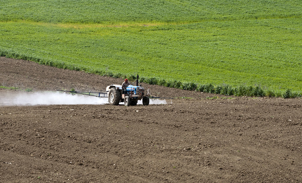 tracteur pulvérisant des pesticides dans un champ